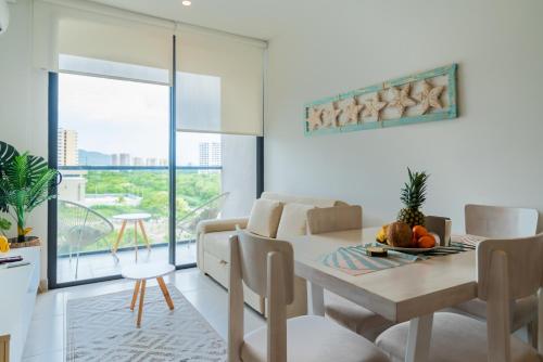 eine Küche und ein Esszimmer mit Tisch und Stühlen in der Unterkunft Nuevo apto familiar cerca al mar in Santa Marta