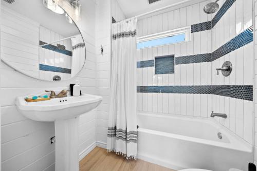 een witte badkamer met een wastafel en een spiegel bij Secluded beachfront home with panoramic ocean views, private pool and huge deck in Hercules Offshore Heliport