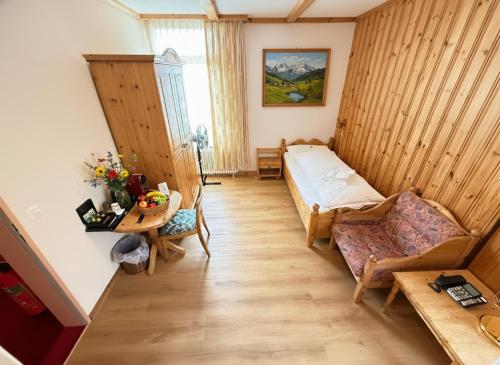 una pequeña habitación con una cama y una mesa en Beatenberg Resort & Spa in Beatenberg Interlaken, en Beatenberg