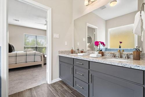 a bathroom with two sinks and a large mirror at Beautiful home with lake views and in-ground pool in West Livingston