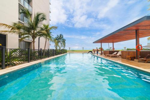 ein großes Schwimmbad mit einem Pavillon neben einem Gebäude in der Unterkunft Nuevo apto familiar cerca al mar in Santa Marta