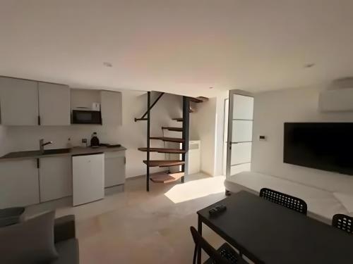 cocina y sala de estar con armarios blancos y mesa en Canto Cigalo Duplex no 11, en Robion en Luberon