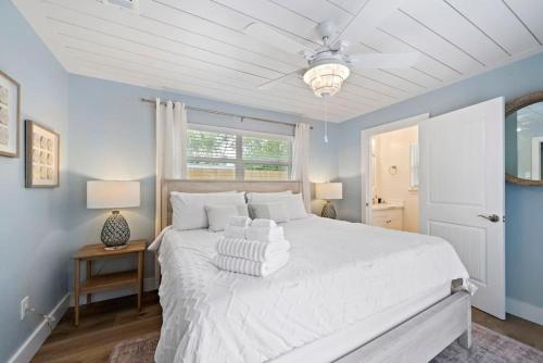 Un dormitorio con una cama grande blanca con ventilador de techo. en Beautiful home with pool near Kemah Boardwalk, en Kemah