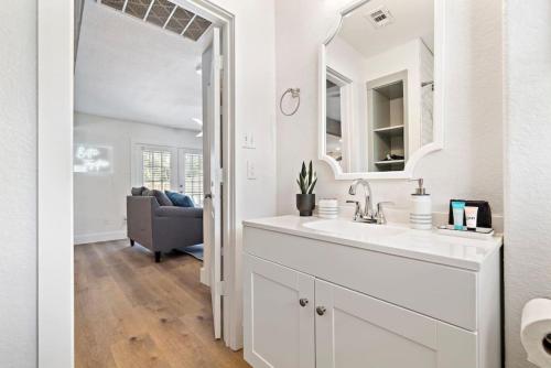 Un baño blanco con lavabo y espejo. en Beautiful home with pool near Kemah Boardwalk, en Kemah