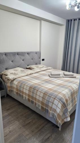 a bedroom with a bed with a plaid blanket at AIRPORT/PARKING/VINIETA.MD in Chişinău