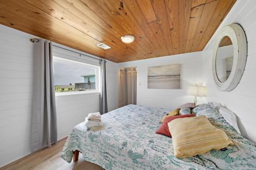 瑟夫赛德海滩Beach Home With Game Room, Tiki Bar and Fire Pit的卧室里有一张带木质天花板的床
