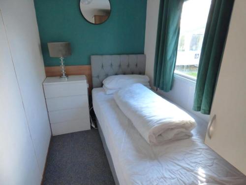 Un dormitorio pequeño con dos camas y una ventana. en Delightful Caravan With A Lake View At Southview Holiday Park Ref 33026Cl, en Winthorpe
