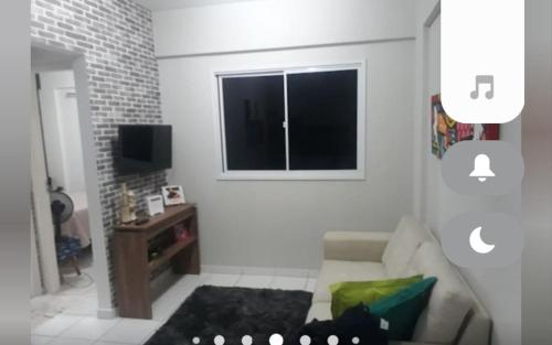 Una sala de estar con un sofá y una ventana. en Apartamento em Messejana com lazer completa apto inteiro, en Fortaleza