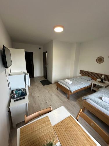 a living room with a bed and a table at Willa BROWAR - Komfortowe Pokoje w Centrum in Starogard Gdański