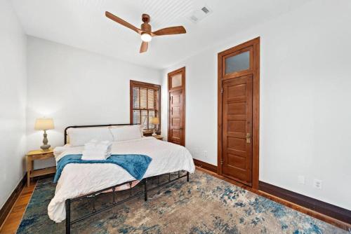 Historic loft in downtown Galveston close to everything في جالفيستون: غرفة نوم بها سرير ومروحة سقف