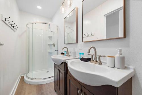 a white bathroom with two sinks and a shower at Historic Downtown Galveston Flat With Game Room in Galveston