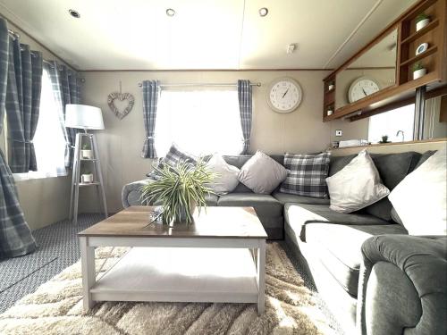 una sala de estar con un sofá y una mesa en Seashell Retreat, en Cayton