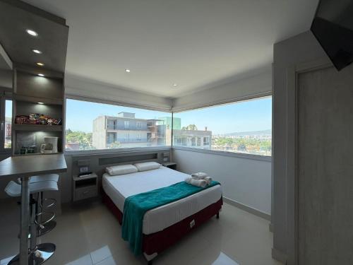 ein Schlafzimmer mit einem Bett und einem großen Fenster in der Unterkunft Suite La Posta in San Salvador de Jujuy