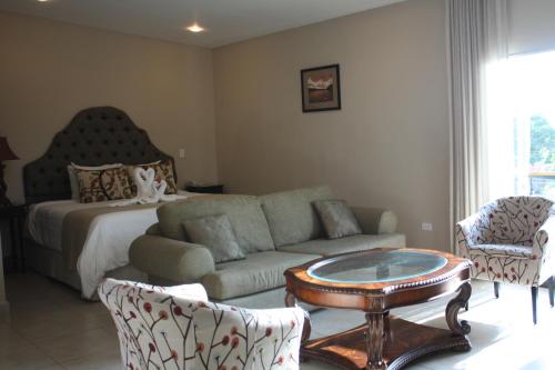 a living room with a couch and a bed at Hotel Gran David in Santiago
