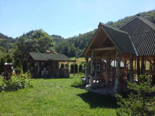 a couple of buildings in a field of grass at Staparski Sorrento in Užice