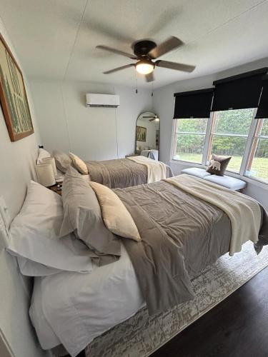 a bedroom with two beds and a ceiling fan at The Ozark Stargazer in Western Grove