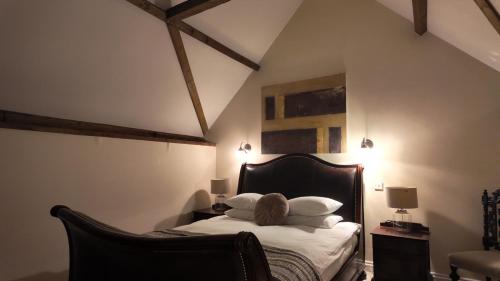 a bedroom with a bed with white sheets and pillows at The Fat Fox in Pyrton
