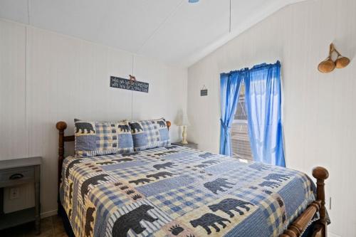 a bedroom with a bed and a window with blue curtains at Tucked Away - Magical Location on the River, Hiking, and Rafting in Dillsboro