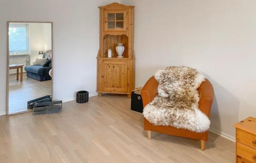 a living room with an orange chair with a blanket at Nice Apartment In Hyltebruk With Wifi in Hyltebruk