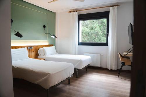 a hotel room with two beds and a window at El Ciervo in Villaciervos