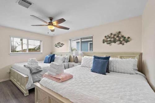 a bedroom with two beds and a ceiling fan at Waterfront beach house with the ultimate game room and two docks in Oyster Creek
