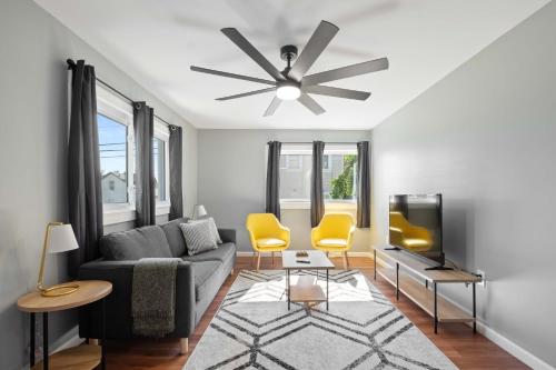 a living room with a couch and a ceiling fan at Sensation on Salisbury in Pittsburgh
