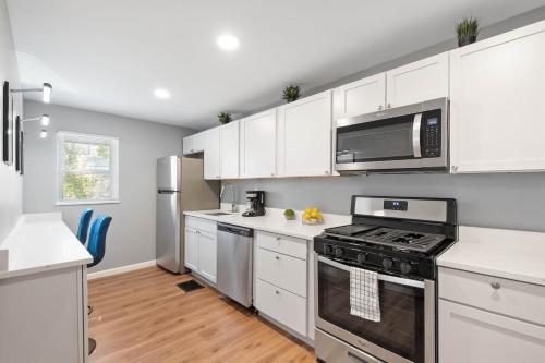 a kitchen with white cabinets and a stove top oven at Sensation on Salisbury in Pittsburgh
