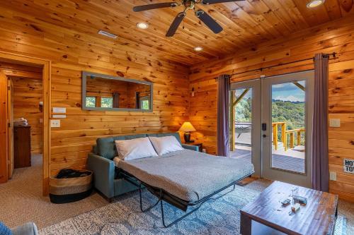 ein Schlafzimmer mit einem Bett in einer Blockhütte in der Unterkunft River View Retreat in Boone