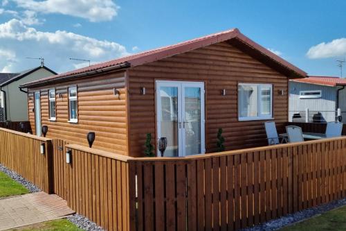 a log cabin with a wooden fence at Captivatingly Stunning 2-Bed Chalet in Bridlington in Bridlington