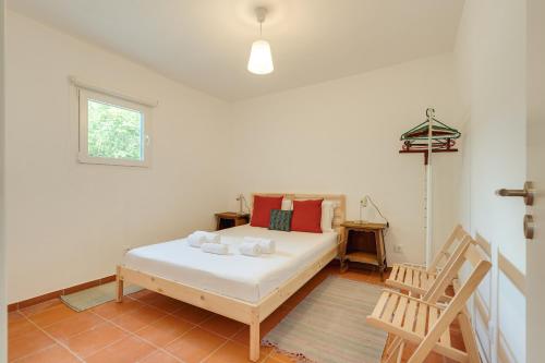 a bedroom with a bed and a window and a chair at NEW! Quinta de Zanão House in Palmela