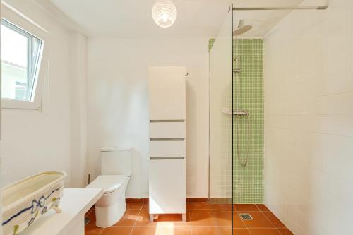 a bathroom with a toilet and a glass shower at NEW! Quinta de Zanão House in Palmela