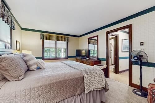 a bedroom with a large bed and a television at Trent Jones Cottage at Point O' Woods in Benton Harbor
