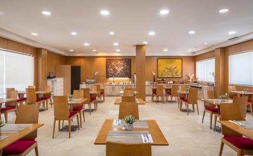 サン・セバスティアン・デ・ロス・レイエスにあるSercotel de los Reyesの木製のテーブルと椅子、カフェテリアのあるレストラン