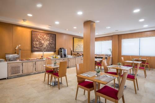 サン・セバスティアン・デ・ロス・レイエスにあるSercotel de los Reyesのテーブルと椅子とキッチンのあるレストラン