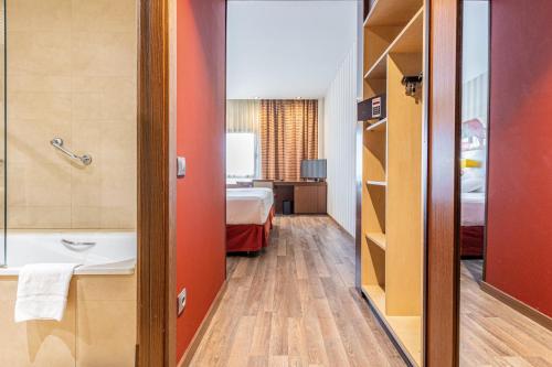 a hotel room with a bathroom with a bed and a sink at Sercotel Las Artes Pinto in Pinto