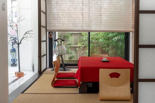 een eetkamer met een rode tafel en een raam bij Exceptional Luxury w Leisure Facilities in Teddington