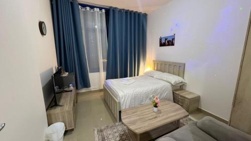 a small room with a bed and a table in it at Banny Homes - Hostel Apartments in Abu Dhabi