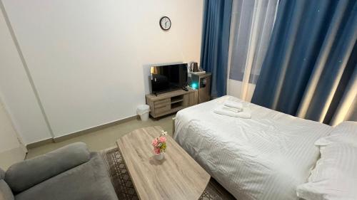 a room with a bed and a couch and a tv at Banny Homes - Hostel Apartments in Abu Dhabi