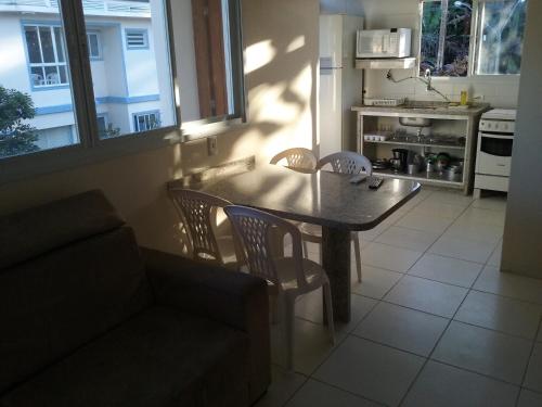 a living room with a table and a couch and a kitchen at Pousada e Camping Lagoa da Conceição in Florianópolis