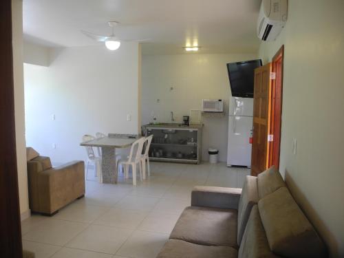 a living room with a couch and a table and a kitchen at Pousada e Camping Lagoa da Conceição in Florianópolis