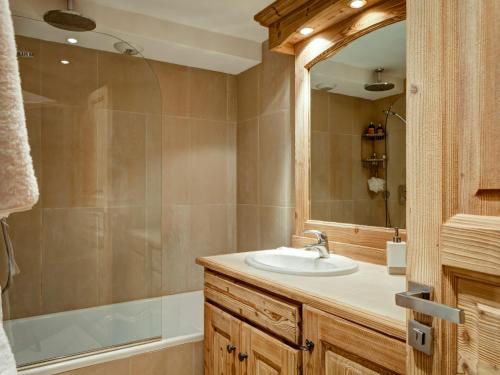a bathroom with a sink and a tub and a mirror at Appartement de standing au centre de Courchevel 1850, en bord de piste et avec terrasse - FR-1-514-35 in Courchevel