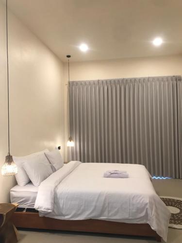 a bedroom with a large white bed and a window at Permata Villas Lombok in Kuta Lombok