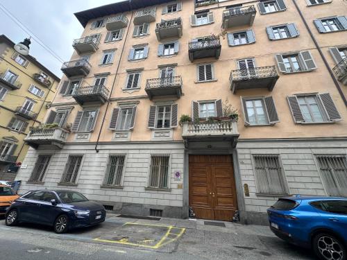 a building with two cars parked in front of it at Suite 21 Eleganza e Comfort in Torino in Turin
