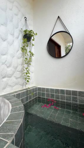 Un baño con espejo y un charco de agua. en Suite paradise, en Amontada