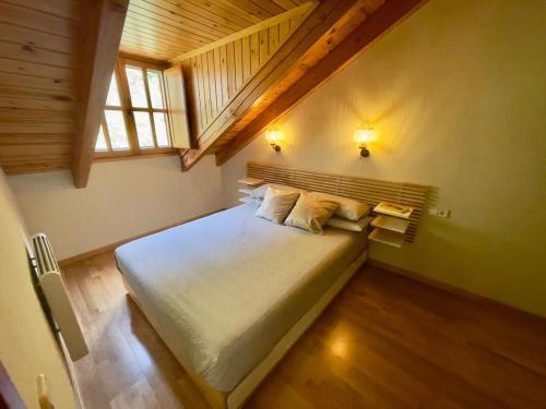 a bedroom with a large bed in a attic at Dúplex a 20 min de Aigüestortes in Escaló