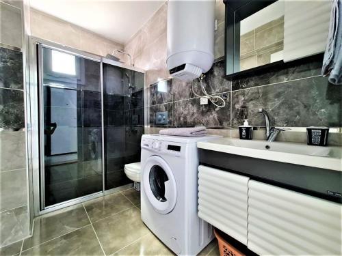 une salle de bains avec lave-linge et lavabo dans l'établissement Very hygienic apartment close to the center and the airport, à Dalaman