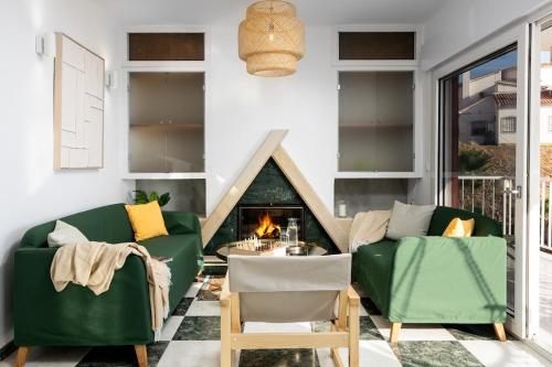 un salon avec deux canapés verts et une cheminée dans l'établissement Villa Miramar with Pool, BBQ, Billiard & Sea View, à Torre de Benagalbón