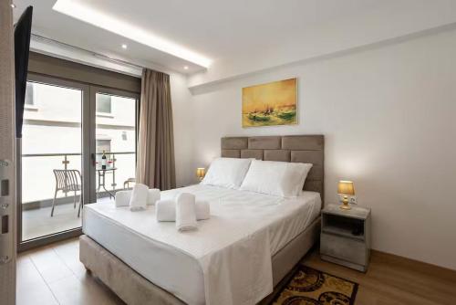 a bedroom with a large bed and a balcony at Astir Apartments Kalamata in Kalamata