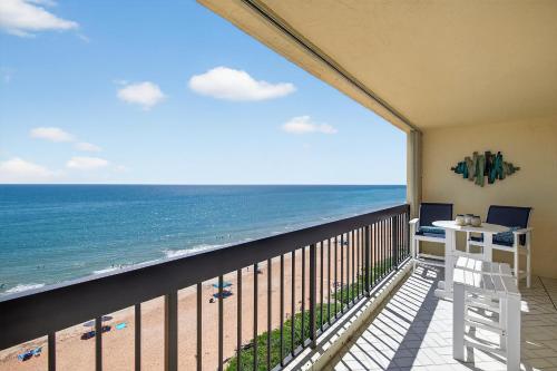un balcón con vista a la playa en Renovated direct oceanfront condo with spacious balcony, heated pool, and garage parking, en Ormond-by-the-Sea