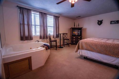 a bedroom with a bed and a tub next to a bed at Bear Camp By The Night in Pigeon Forge